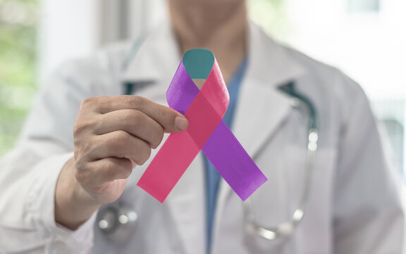 Thyroid cancer awareness ribbon for September month in teal pink blue symbolic bow color on doctor hand support in medical hospital background