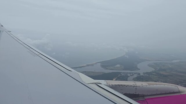 Passenger window view on approach to Gdansk above the Baltic coast near river estuary.