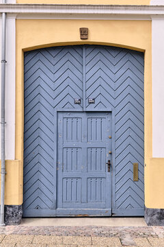 Viborg, Denmark - 07 August 2026: View of a blue chevron-patterned wooden door with house numbers 33A and 33B set in a yellow historic building in the old town of Viborg.