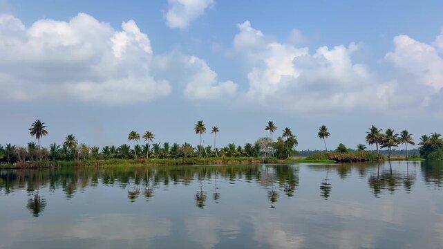 Scenic view of Kerala backwaters with calm waters, lush greenery, and cloudy sky, capturing the serene beauty and tranquil lifestyle of Kerala