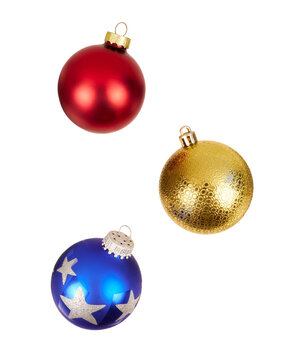 three different colored christmas balls in red, blue and gold falling isolated on white or transparent png