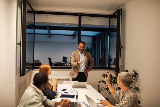 Manager taking questions from team in conference room