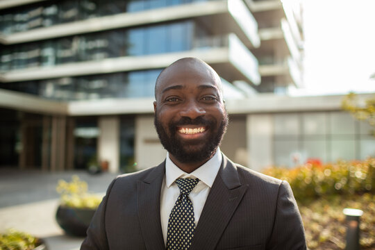 Smiling businessman in suit outside modern office