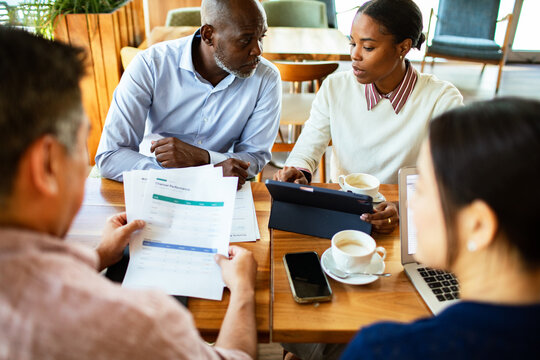 Coworkers reviewing analytics on tablet at coffee shop