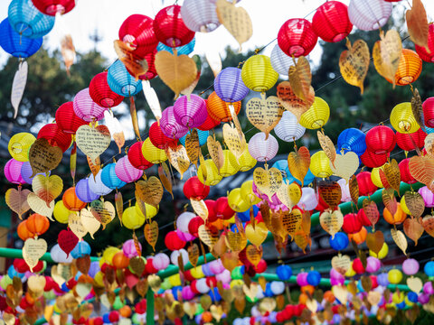 Busan, South Korea - 14 February 2026: View of colorful paper lanterns and golden leaf-shaped prayer tags hanging at Haedong Yonggungsa Temple.