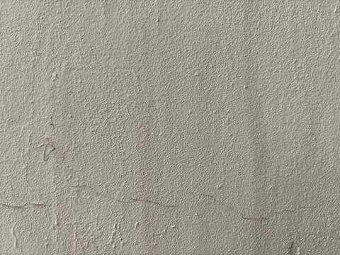 Fine grain beige stucco exterior wall texture background close up