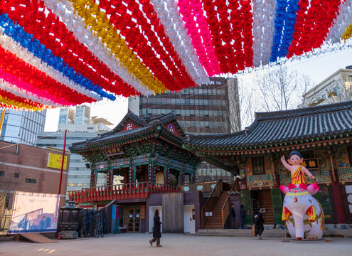 Busan, South Korea - 09 February 2026: View of Samgwangsa Temple decorated with colorful lotus lanterns, featuring traditional Korean architecture and a baby Buddha statue.