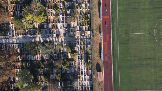 Aerial top down view of running track near cemetery representing life and death