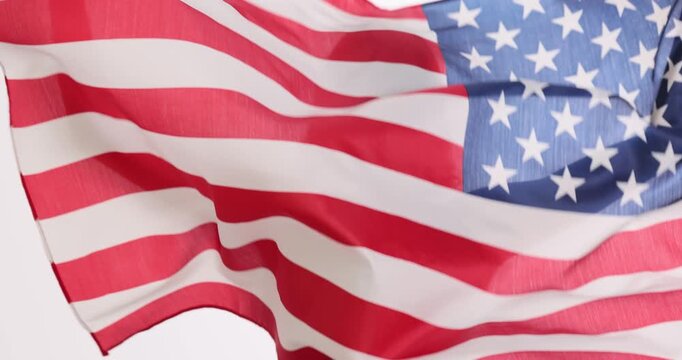 Woman activist holds large American flag waving above head. Devoted supporter holds enormous flag participating in public demonstration. Slow motion