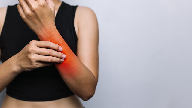 Woman with Forearm Pain and Inflammation, Holding Her Arm with Red Highlighted Area for Muscle Strain and Healthcare Concept