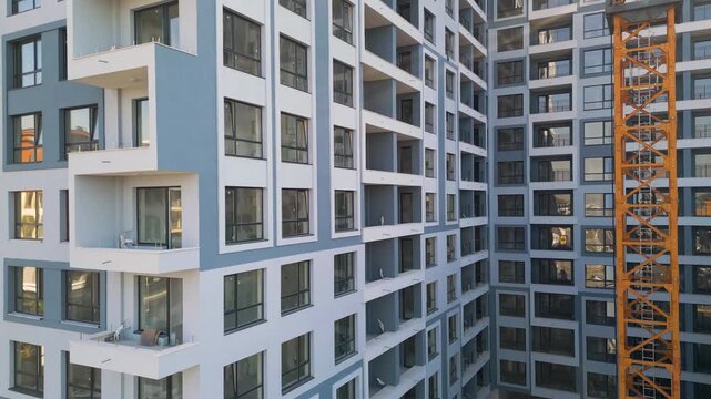 Modern residential building construction site with yellow tower crane facade