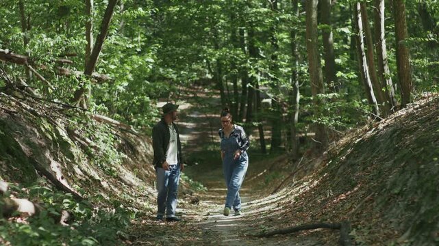 Hikers Using Smartphone GPS Navigation and Talking in Forest