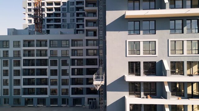 Modern residential building construction site with yellow tower crane facade