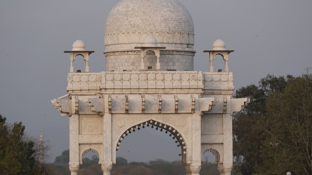 Islamabad, Pakistan - 03 October 2022: View of the white marble structure in Fatima Jinnah Park, featuring an elegant dome and arched entrance surrounded by lush trees.