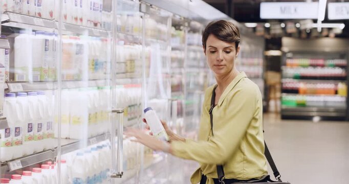 Woman, shopping and watch at store for groceries, fresh milk and comparing brand for online list. Person, wristwatch and checklist in supermarket with ingredients, dairy products and food essentials