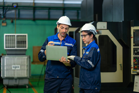Team of industrial worker is checking the setup value of  metal casting machine by automated monitor while working inside factory for safety industry