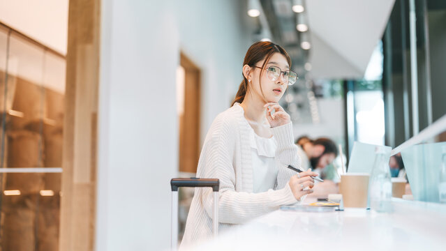 Beautiful young adult business asian woman using laptop work and travel using wireless digital technology at coffee cafe