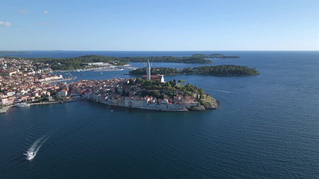 Aerial wide panorama of Rovinj old town peninsula, speed boat wake, and coastal archipelago in Istria Croatia