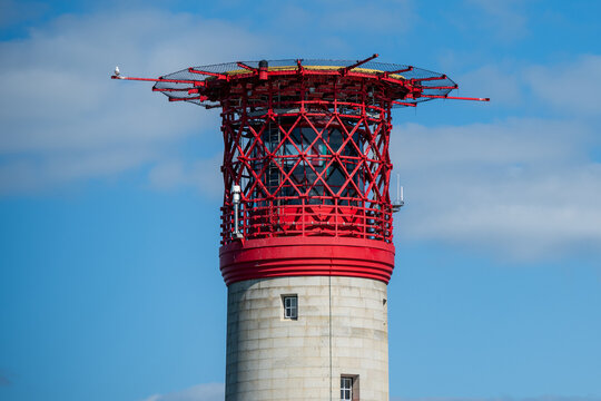 Alum Bay, England - 05 September 2026: View of the iconic red and white The Needles Lighthouse featuring its distinctive lattice structure and helipad against a clear blue sky.