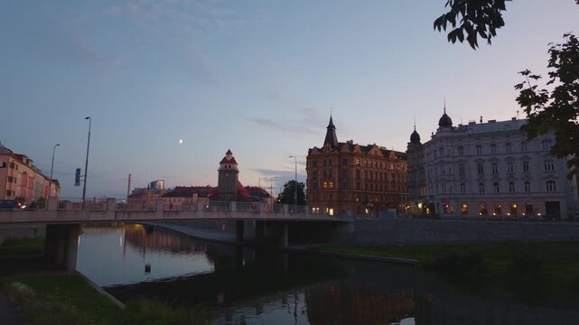 View of historic architecture along the Morava River at dusk in Olomouc, Olomouc Region, Czechia.