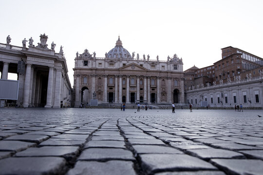 Vatican City, Vatican City - 03 October 2022: View of St. Peter's Basilica in St. Peter's Square with cobblestone ground and people walking.