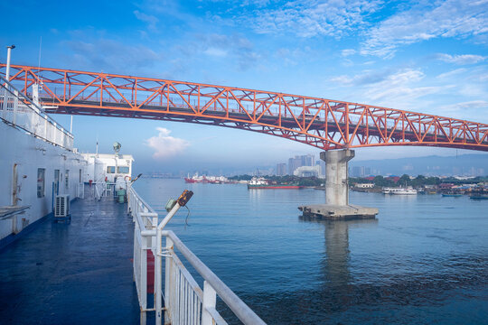View of the Cebu Port Authority area from a ferry boat passing under the old Mactan-Cebu bridge Cebu City, Central Visayas, Philippines.