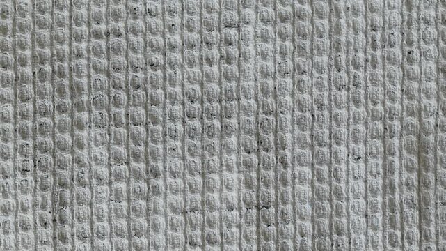 White waffle fabric texture slowly rotating. Abstract background with cotton textile material. Macro shot of cloth surface pattern