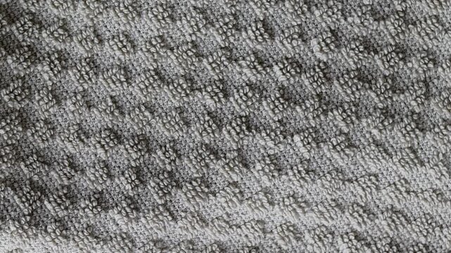 Gray terrycloth towel texture rotating in a macro view. Abstract cotton fabric background with checkered pattern and soft fiber