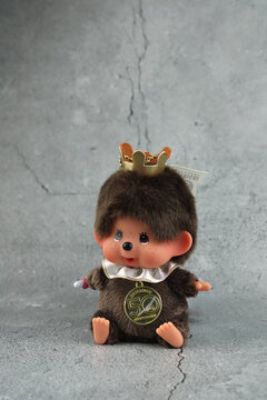 popular monkey classic doll toy , Monchichi or Monchhichi , Japanese cute pilot costume monkey fur doll display on stone table with grey wall background in souvenir tourist shop 50 years Anniversary
