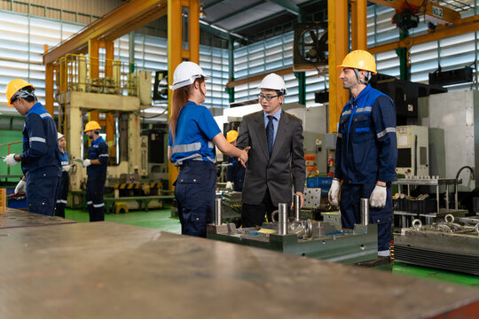 A factory manager greets a female technician while another worker stands nearby, presenting a workplace scene about leadership, teamwork, professional cooperation, and manufacturing operations.