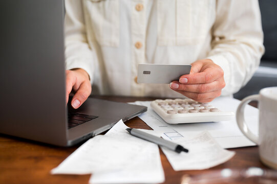 Woman making an online card payment while managing personal finances
