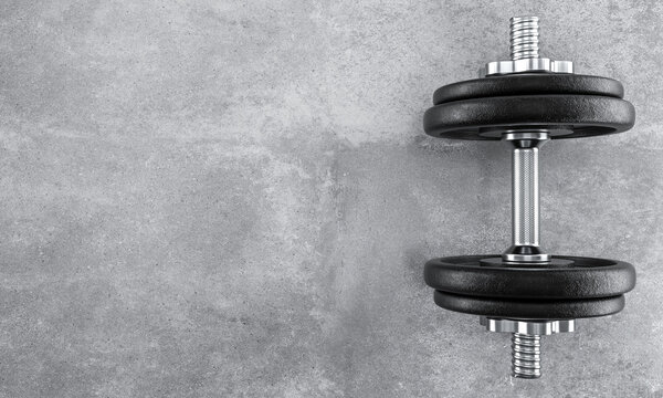 Dumbbell on gray concrete background