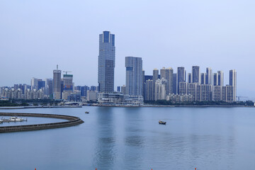 Fototapeta premium Modern Waterfront Skyline with High-Rise Towers and Calm Water