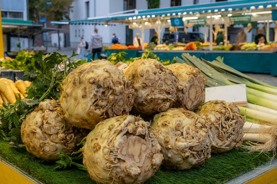 Fresh celeriac and leeks displayed for sale at a weekly outdoor market