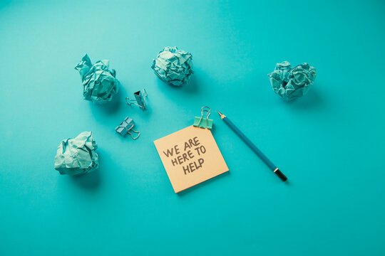 We are here for help, message on sticky note with paper clip