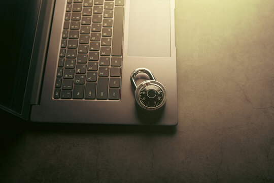 Laptop and padlock on dark background. Security and safety concept.