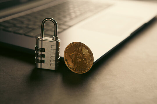 Laptop with bitcoin and padlock. Cryptocurrency security concept.