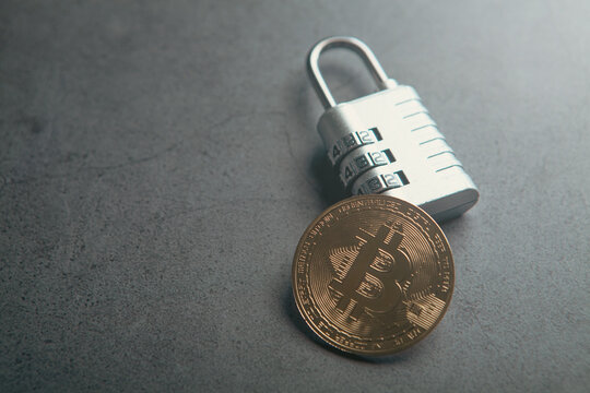 Bitcoin and padlock on dark background. Cryptocurrency security concept.