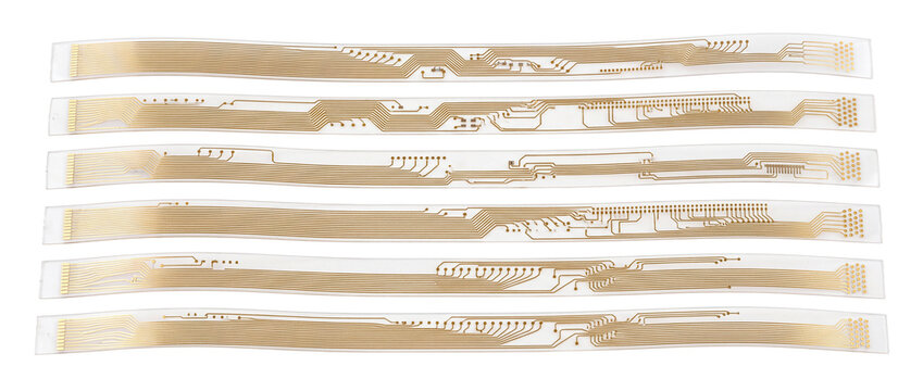 Flexible circuit board ribbon cable strips with gold conductors on black background for electronic microtechnology engineering and modern hardware component design, isolated closeup view.