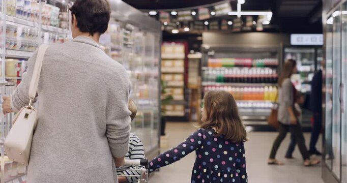 Mom, children or trolley at supermarket for shopping, dairy aisle or greet worker for respect. Mother, kids or cart at store with milk selection, family retail outing or grocery sale on food supplies