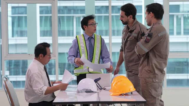 Architect engineer and construction worker in safety vest and hard hat review blueprint construction plan at office table during collaboration for building project planning