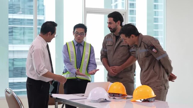Engineer and construction worker in safety vest and hard hat handshake with business professional during office meeting for partnership agreement, blueprint review, workplace safety planning