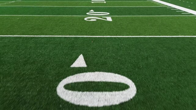 American football field low POV flyover showing yard lines and hash marks