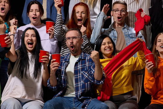 Passionate hockey fans react to dramatic match moment in stadium stands with roaring excitement. Sports viewing, emotional reaction and supporter loyalty concept.