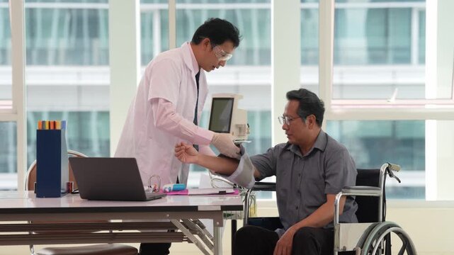 Doctor and adult patient using wheelchair during clinic examination with laptop, medical professional providing healthcare consultation, disability support, rehabilitation and mobility care