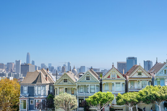 Iconic row of colorful Victorian painted ladies houses at Alamo Square with the impressive San Francisco financial district skyline in the background on a perfectly clear sunny northern California day