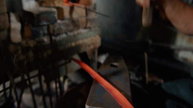 Blacksmith Forging Glowing Hot Metal Bar on Anvil with Hammer