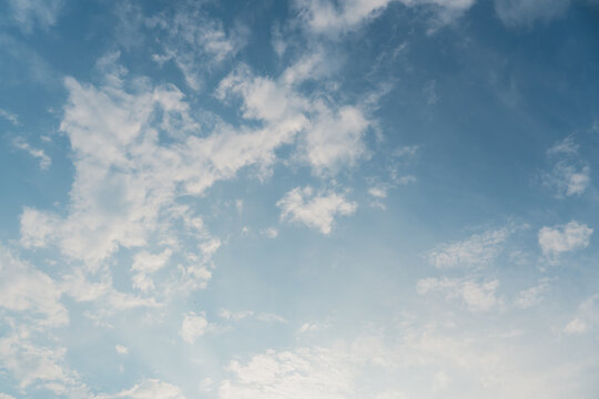 In a sky with a gradient from deep blue to pale white, many scattered fine white clouds are visible.
