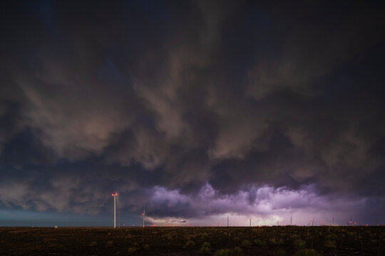 Lightning over wind turbines during storm receding