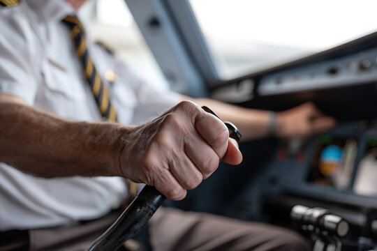 Professional Airline Pilot Operating Flight Controls in Cockpit